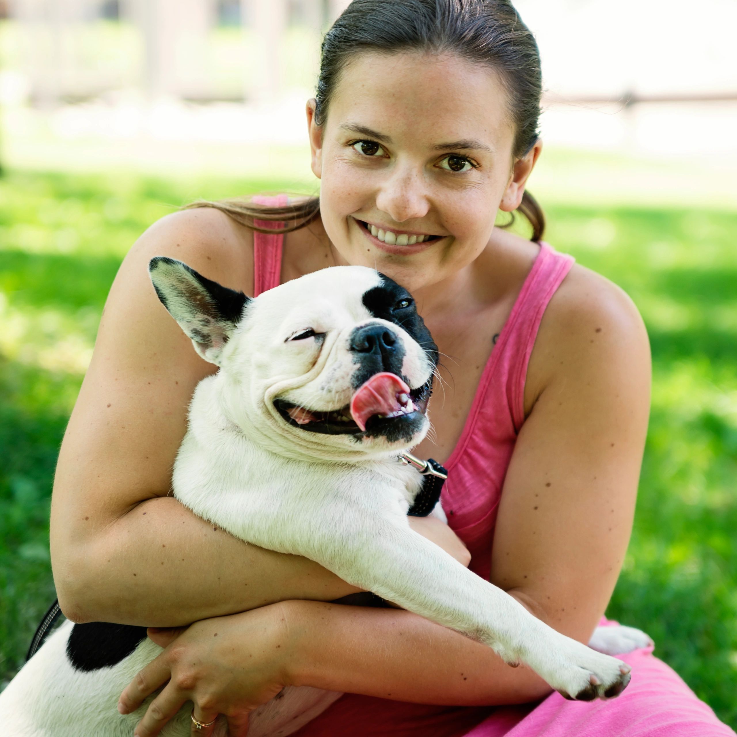 Pet caregiver with a small dog in a park